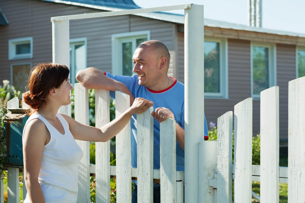 Book Online Couple Talking Near White Fence